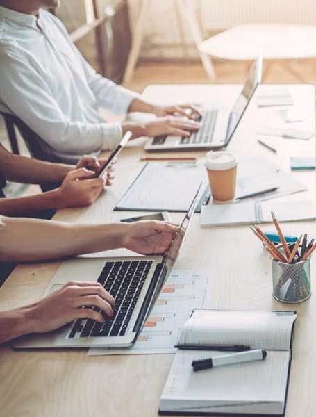 Young People Work In Modern Office Cropped image of multiracial young creative people in modern office. Group of young business people are working together with laptop tablet smart phone notebook. Successful hipster team in coworking. Freelancers.